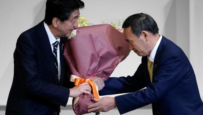 Shinzo Abe und Yoshihigo Suga nach der Wahl zum neuen Parteivorsitzenden. (Bild: AFP/Eugene Hoshiko)