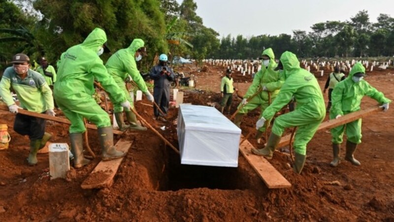 Särge von Covid-19-Opfern werden in Indonesien ausschließlich in Schutzausrüstung beerdigt. (Bild: AFP)