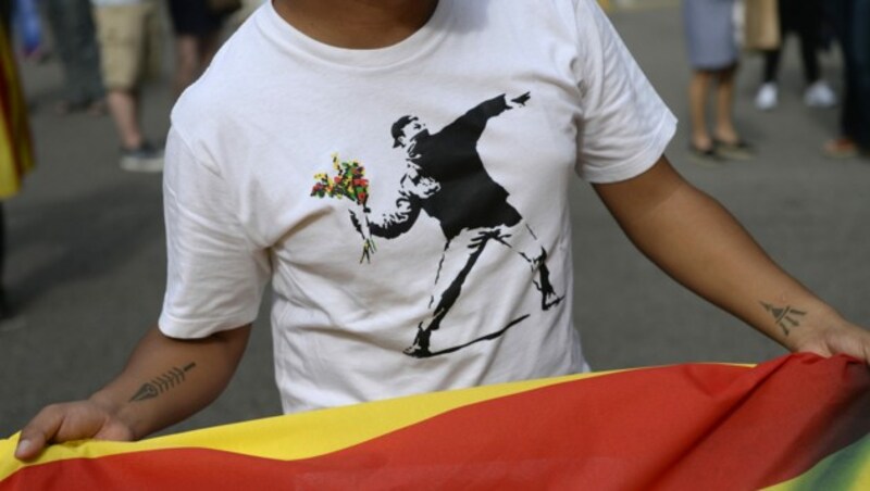 Ein katalanischer Demonstrant trug bei einem Protest das berühmte Motiv von Banksy. (Bild: AFP )