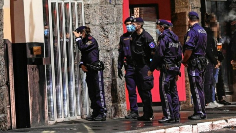 Polizeibeamte halten Nachschau, ob noch Gäste in den Lokalen der sogenannten Bogenmeile in Innsbruck anzutreffen sind. Sperrstunde-Kontrollen gab es aber in ganz Österreich. (Bild: zeitungsfoto.at/Daniel Liebl)