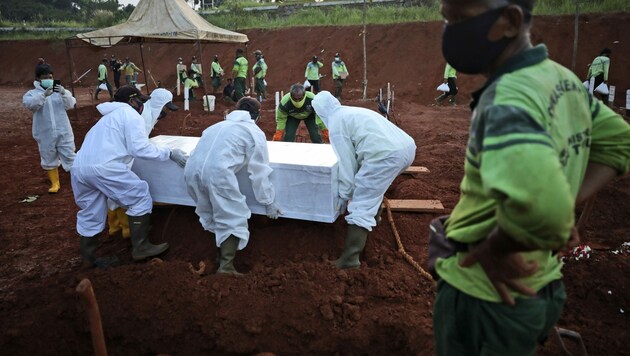 Auf einem Friedhof vor den Toren von Jakarta (Indonesien) heben Totengräber fast ununterbrochen neue Gräber für Coronavirus-Tote aus. (Bild: The Associated Press)
