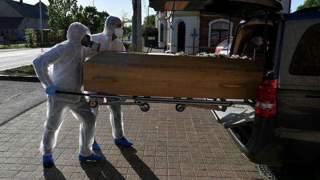 Die Mitarbeiter eines Bestattungsunternehmens außerhalb des Saint-Luc Krankenhauses in der belgischen Stadt Namur. (Bild: AFP)