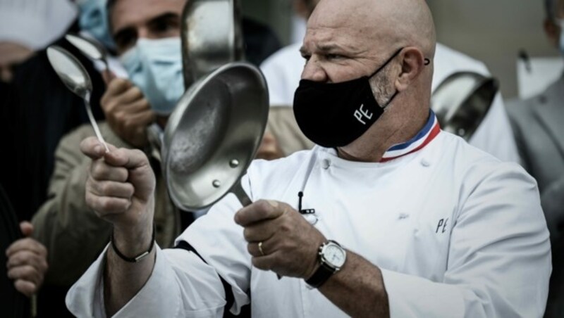 Philippe Etchebest protestiert mit Kollegen, schwarzem Armband und Pfanne außerhalb seines Restaurants „Le Quatrieme Mur“ in Bordeaux gegen die Corona-Maßnahmen der französischen Regierung. (Bild: APA/AFP/Philippe LOPEZ)