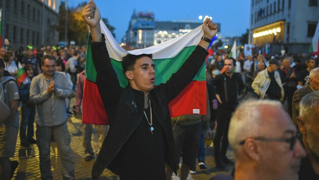 Dieser Bulgare hält die Nationalflagge bei seinem Protest gegen die Regierung hoch. (Bild: AFP)