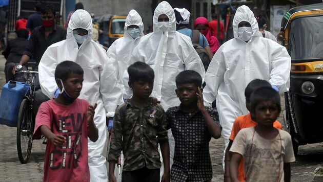 Mitarbeiter der indischen Gesundheitsbehörde unterwegs zu einem Coronavirus-Screening in Mumbai (Indien) (Bild: AP)