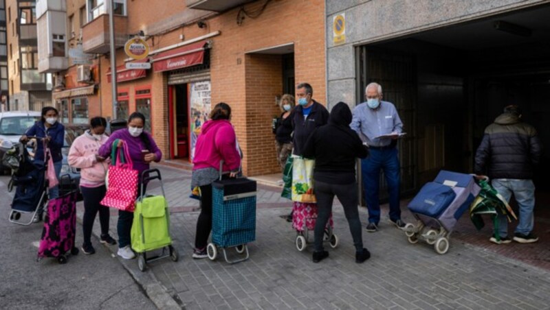 In Madrid stellen sich zahlreiche Menschen vor Essensausgabestationen an. Die Corona-Krise hat Spanien auch wirtschaftlich schwer getroffen. (Bild: AP)