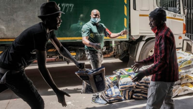 Freiwillige verteilen Essenspakete in der südafrikanischen Stadt Johannesburg. (Bild: AFP)