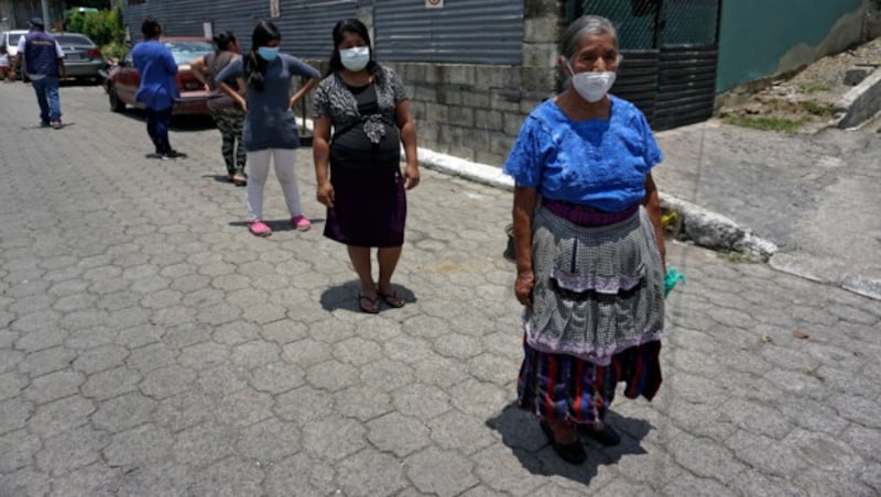 In Guatemala stellen sich Frauen mit Maske und Sicherheitsabstand vor einer Suppenküche an. (Bild: AFP)