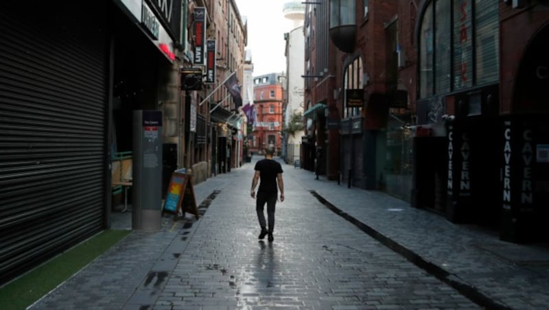 Ein einsamer Passant in einer Straße voller Pubs in Liverpool - Bars und Restaurants mussten, sofern sie keine Hauptmahlzeiten anbieten, schließen. (Bild: AP)