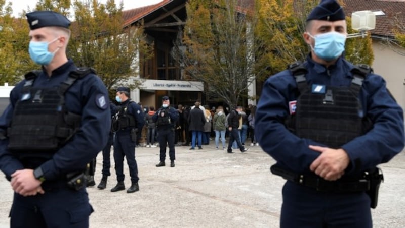 Die französische Polizei bewacht jene Schule in Conflans-Sainte-Honorine, vor der ein mutmaßlich islamistisch motivierter Täter den Lehrer Samuel P. ermordet hat. (Bild: AFP)