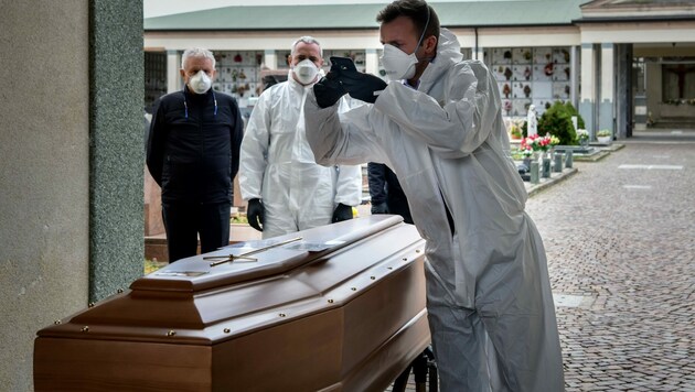 März 2020: Ein Sargträger in Bergamo macht ein Foto für die Angehörigen eines Covid-19-Todesopfers. Die Trauernden durften aufgrund einer Quarantäneanordnung nicht am Begräbnis teilnehmen. (Bild: AFP)
