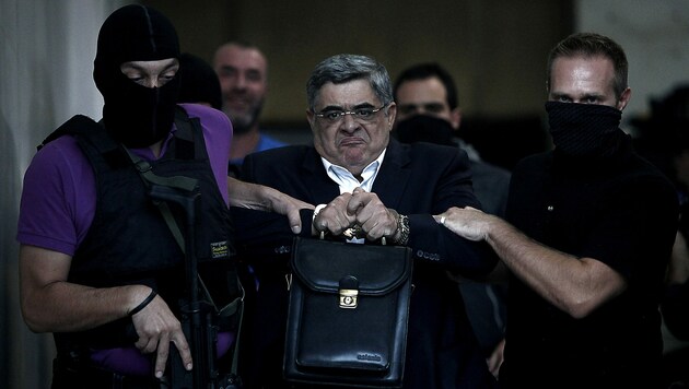 Archivaufnahme aus dem Jahr 2013: Parteichef Nikos Michaloliakos auf dem Weg zur Gerichtsverhandlung (Bild: APA/AFP/ANGELOS TZORTZINIS)