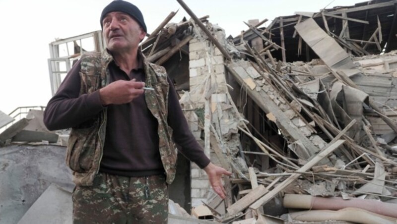 Dieser Mann in Stepanakert, der Hauptstadt Berg-Karabachs, zeigt auf die Reste seines Hauses nach einem Angriff der aserbaidschanischen Armee. (Bild: AP)