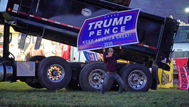 Ein Trump-Anhänger macht vor einer stark befahrenen Autobahnauffahrt Werbung für seinen Favoriten. Bisher haben schon mehr als 69 Mo. US-Amerikaner ihre Stimme abgegeben. (Bild: AP)
