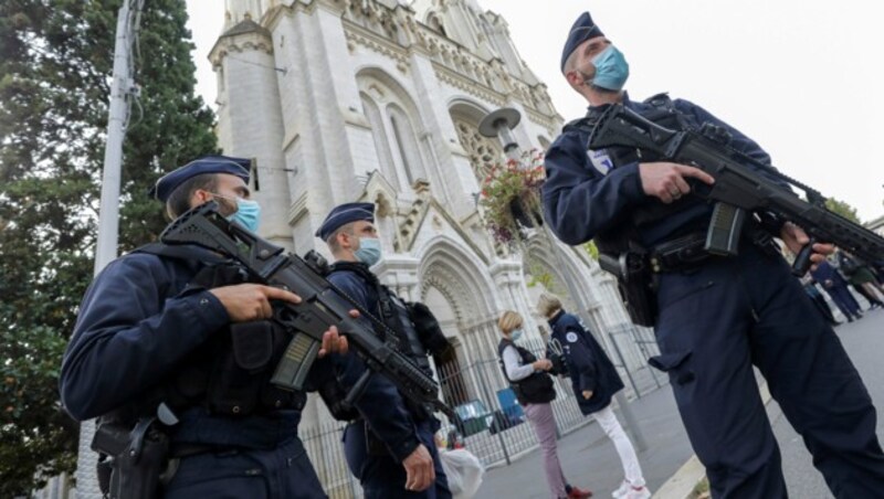 Französische Polizisten bewachen die Notre-Dame-Kirche in Nizza, in der am Donnerstagvormittag ein islamistischer Angreifer zwei Menschen ermordete. Eine weitere Frau tötete der Mann in einer gegenüberliegenden Bar, wo sie sich vor dem Angriff verstecken wollte. (Bild: AP)