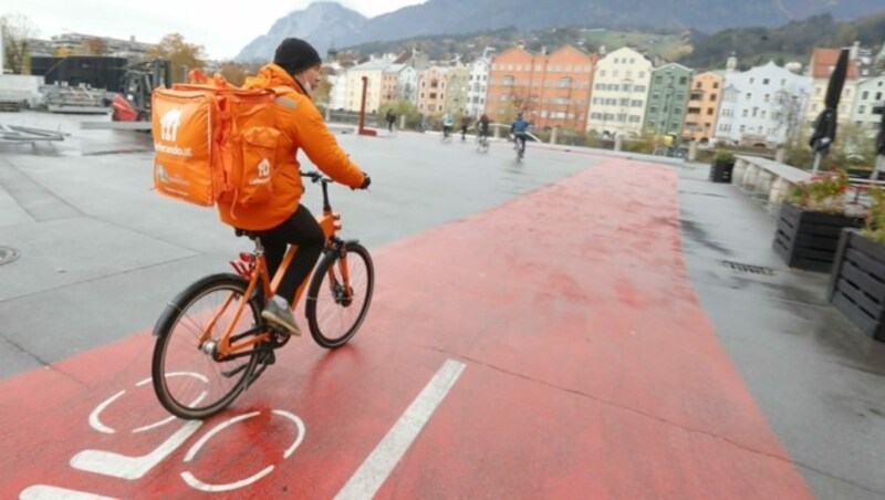 Innsbruck im November 2020: Ein Mann von einem Lieferservice radelt durch die halb leere Stadt. (Bild: Christof Birbaumer)