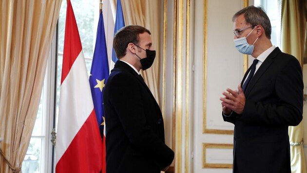 Emmanuel Macron sprach mit Wolfgang Wagner von der österreichischen Botschaft, bevor er sich ins Kondolenzbuch eintrug. (Bild: AFP)
