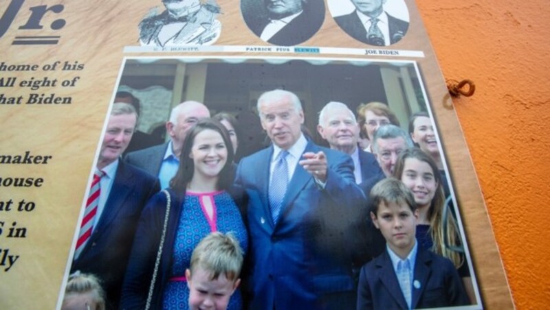 Joe Biden besuchte im Jahr 2017 seine weit entfernten Verwandten in Irland. Ein Foto von dem Besuch hängt an der Fassade eines Hauses in Bidens „Heimatort“ Ballina. (Bild: APA/AFP/PAUL FAITH)