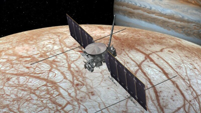 Künstlerische Illustration: Die Raumsonde „Europa Clipper“ im Orbit um Europa. Rechts im Hintergrund ist der Planet Jupiter zu sehen. (Bild: NASA/JPL-Caltech)