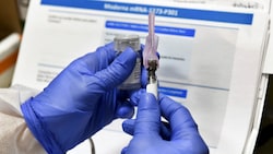 Ein Moderna-Forscher mit einer Dosis des Covid-19-Impfstoffs mRNA-1273 (Bild: Associated Press)