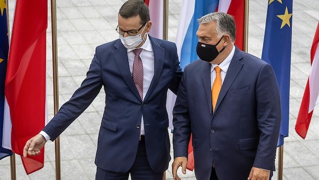 Die Ministerpräsidenten Mateusz Morawiecki (Polen, li.) und Viktor Orban wollen sich eigenen Angaben zufolge nicht von der EU „erpressen lassen“. (Bild: APA/AFP/Wojtek RADWANSKI)