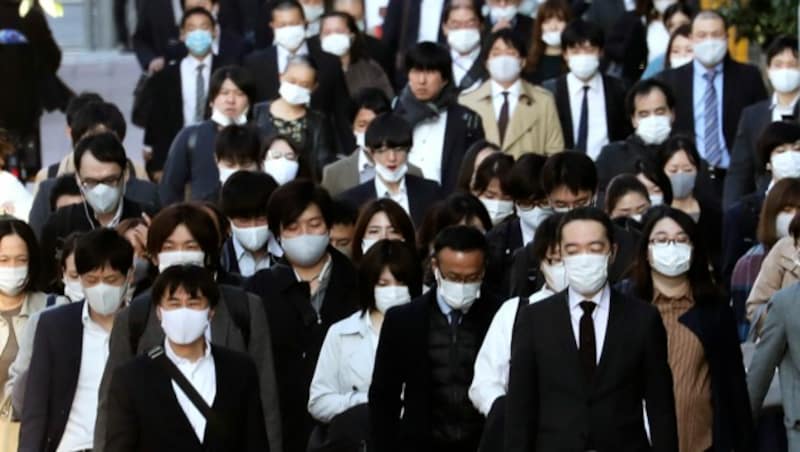 Die Menschen tragen Masken, aber die Straßen sind voll in Tokio. (Bild: AP)