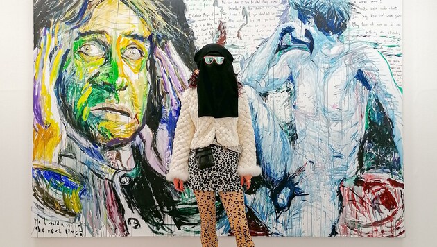 Die Wiener Multi-Künstlerin Elke Silvia Krystufek mit Hidschab vor ihrem Acrylgemälde aus 2009 mit dem Titel: „You don´t want to be one of those Picabias you say“. (Bild: Galerie Bernd Kugler)