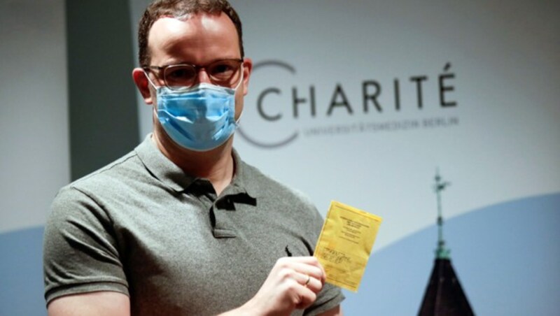 Der deutsche Gesundheitsminister Jens Spahn (CDU) mit einem Impfpass. (Bild: APA/AFP/POOL/HANNIBAL HANSCHKE)