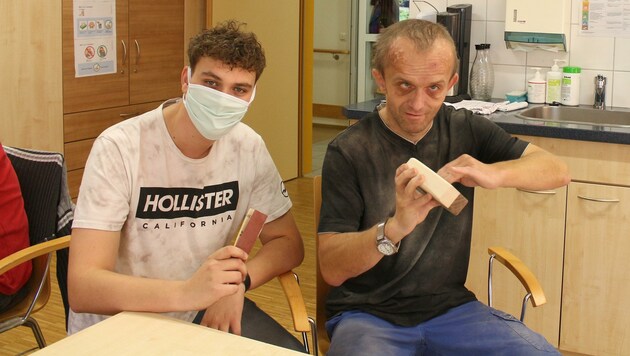 Jonas Atteneder mit dem Beschäftigten Simon Windischhofer beim Schleifen in der Holzwerkstatt. (Bild: Lebenshilfe Oberösterreich)
