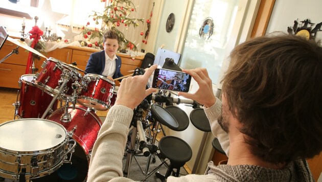 Musikschuldirektor Matej Krevs zeigt mit Julian am Schlagzeug, wie die Videos entstanden. (Bild: Hronek Eveline)