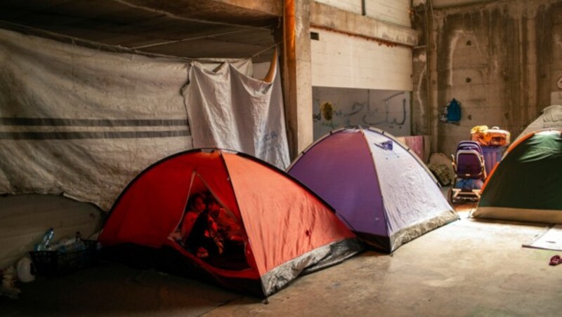 Zwei Flüchtlingskinder spielen in einem verlassenen Gebäude auf Lesbos in einem Zelt. (Bild: APA/AFP/ANGELOS TZORTZINIS)