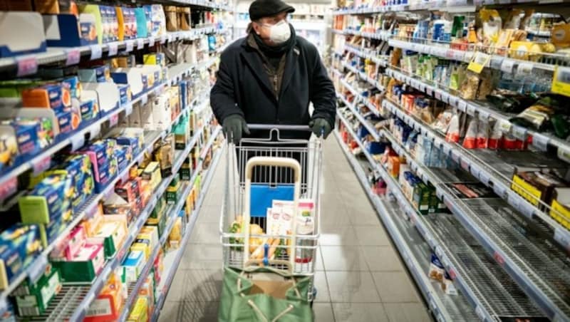 Ein Kunde kauft mit Mundschutz und Handschuhen in einem Supermarkt im Berliner Stadtteil Friedenau ein. (Bild: APA/dpa/Kay Nietfeld)