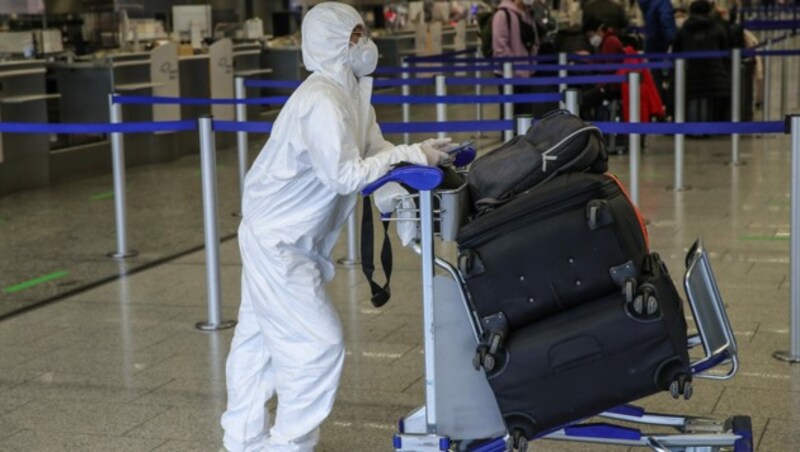 Ein Passagier am Flughafen Frankfurt in Schutzkleidung (Bild: AFP)