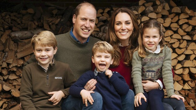 Die Weihnachtskarte 2020 von Prinz William und Herzogin Kate zeigt das Paar mit seinen Kindern Prinz George, Prinz Louis und Prinzessin Charlotte vor einem Holzstapel auf dem Landsitz Anmer Hall. (Bild: APA/Matt Porteous/The Duke and Duchess of Cambridge/Kensington Palace via AP)