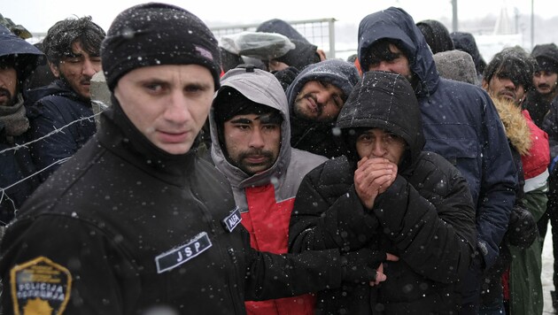 Im abgebrannten Lager Lipa gestrandete Migranten warten auf ihre Essensration. (Bild: AP)