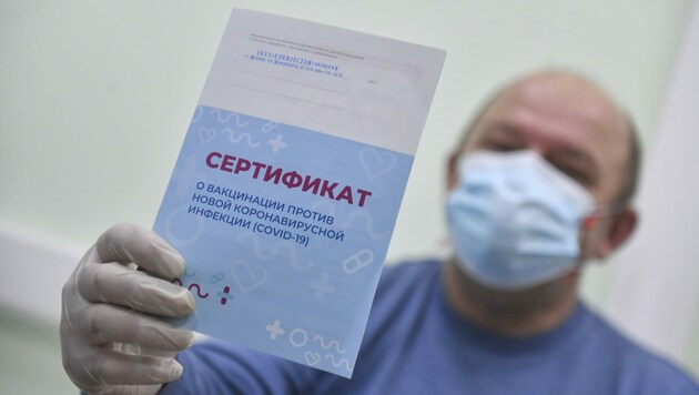 Dieser Russe zeigt nach dem Piks sein Impfzertifikat. (Bild: Moscow News Agency)
