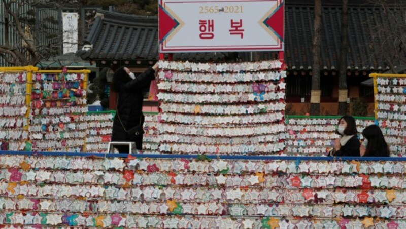 Eine Frau deponiert Neujahrswünsche im Jogyesa Tempel in Seoul. (Bild: AP Photo/Ahn Young-joon)