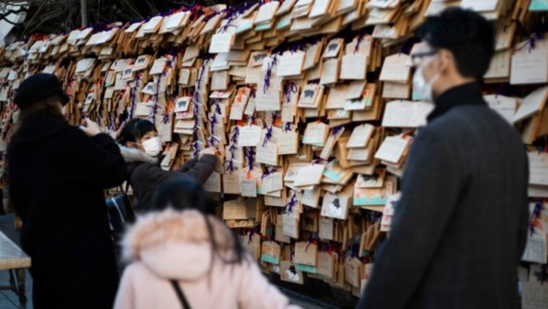 Ein Mädchen platziert in Tokio ihren Neujahrswunsch („ema“). (Bild: AP Photo/Hiro Komae)