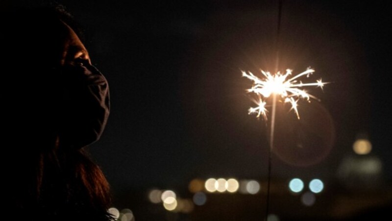 Eine Frau bewundert das Feuerwerk über Rom von ihrer Terrasse aus. (Bild: Tiziana FABI / AFP)