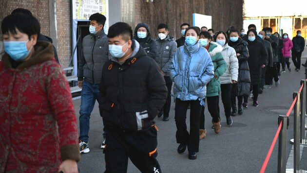 Menschen warten in Peking auf ihre Corona-Impfung. (Bild: AFP)