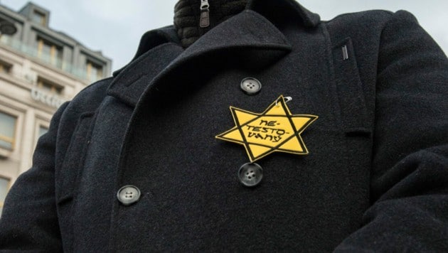 Beim Protest gegen die tschechischen Corona-Maßnahmen hefteten sich Demonstranten einen gelben Davidstern mit „ungetestet“ an ihre Jacken. (Bild: AFP/Michal Cizek)