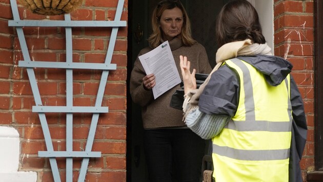 Eine freiwillige Helferin bringt einer Londonerin ein Heim-Testkit. (Bild: APA/AFP/NIKLAS HALLE'N)