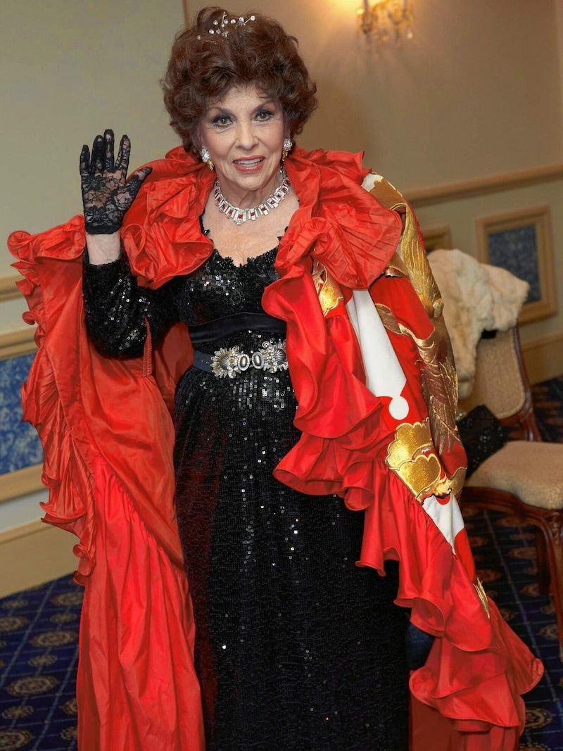 Gina Lollobrigida erschien zum Opernball 2013 in einer schwarz glitzernden Robe, dazu trug sie einen knallroten, gerüschten Seidenumhang, auf dessen Rückseite ein Drache gestickt war. (Bild: Alexander TUMA)