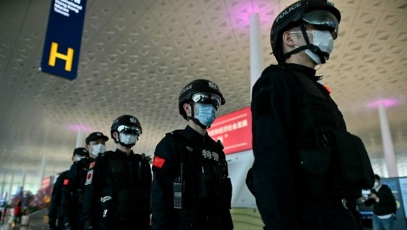 Polizisten am Tianhe Flughafen in Wuhan (Bild: APA/AFP/Hector RETAMAL)