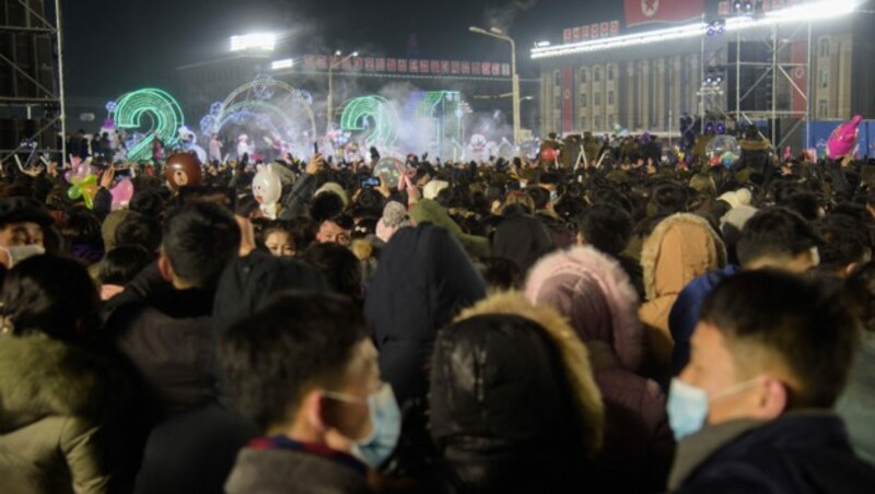 Abgespecktes Silvester in Nordkorea. Obwohl der Erreger offiziell dort nicht vorhanden ist, trugen viele Feiernde einen Mund-Nasen-Schutz. (Bild: AFP)