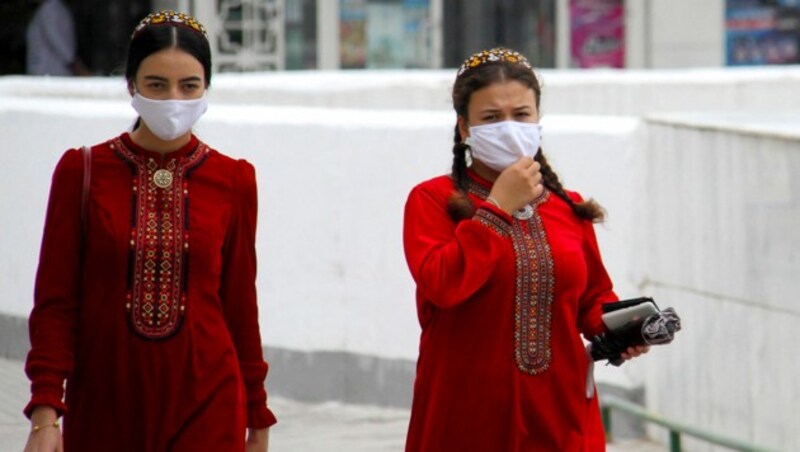 Diese Turkmenischen Frauen gehen auf Nummer sicher und tragen Maske. (Bild: AFP)