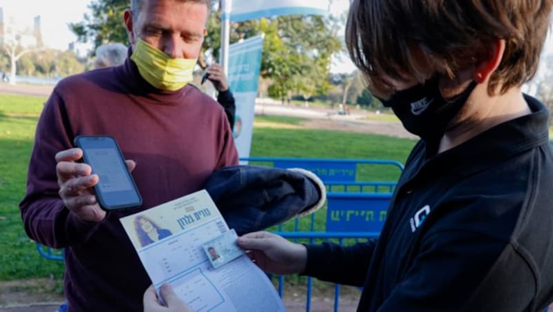 So einfach geht‘s: Vor dem Einlass zeigt dieser israelische Mann seinen „Grünen Pass“ vor und darf sich deshalb ein Konzert in Tel Aviv anschauen. (Bild: AFP)