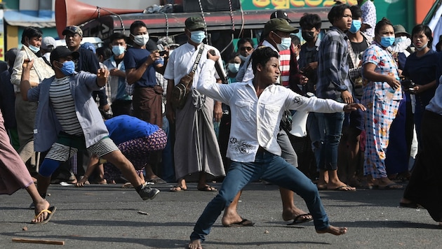 Unterstützer des Militärs werfen Steine auf Demonstranten (Bild: AFP)