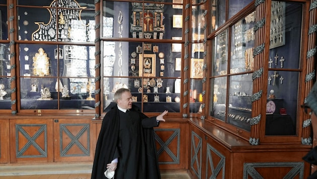 Pater Superior Michael Staberl zeigt die Vitrinen mit den Votivgaben. (Bild: Sepp Pail)