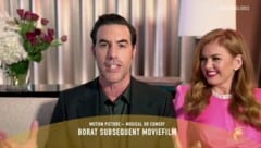 Sacha Baron Cohen freut sich in einer Videoschaltung über die Golden Globes für seinen Film „Borat Subsequent Moviefilm“. Seine Frau Isla Fisher strahlt ihn dabei an. (Bild: APA/AP/2021 NBCUniversal Media, LLC)